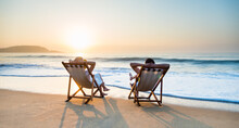 Young Couple Sunbathing On Beach Chair