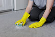 close up of female hands in yellow rubber gloves cleaning carpet with sponge and foam