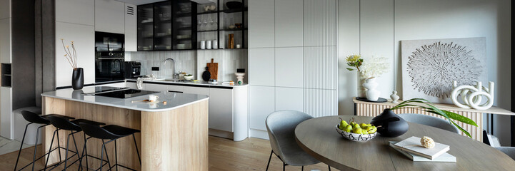 modern composition of kitchen space with design kitchen island, black hookers, grey table, flowers, 