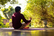 © Wavebreak Media - Focused indian man practicing yoga meditation on sunny terrace, copy space