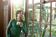 © Wavebreak Media - Indian man drinking coffee and looking out window at home, copy space