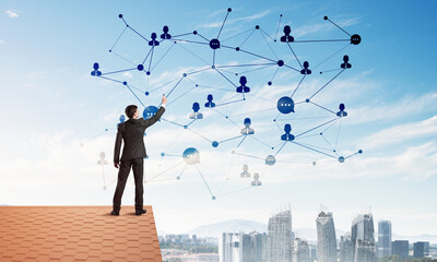 Wall Mural - businessman on house roof presenting networking and connection concept. mixed media