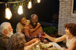 © pressmaster - Happy young man with son toasting with his wife over served table during outdoor family dinner while enjoying spending time together