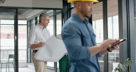 Wall Mural - diverse male and female architects discussing over a plan at office