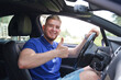 happy driver, young man driving his car looks at the road, not wearing a seat belt, concept of unsafe driving