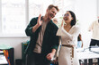 Happy male and female creative coworkers rejoicing with new startup idea making high five gesture during working day in modern office interior, successful employees enjoying business lifestyle