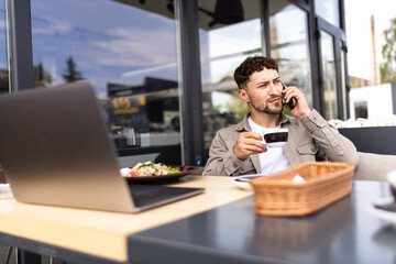 Portrait of male receive international call during remote working in street cafe, skilled IT professional with laptop