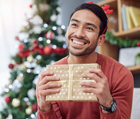 Sticker - Christmas, smile and asian man with gift in his home happy, excited and having fun holiday celebration. Hand holding, box and Japanese male with present in a living room at December party or event