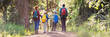© candy1812 - Mother and father with their sons hiking in natural park with backpacks.