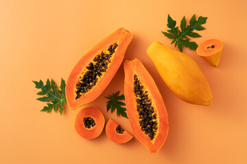 Wall Mural - Cut Papaya over orange table background for tropical fruit design concept.