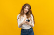 © makedonski2015 - Advertising applications for listening to music. A woman with headphones selects music on her phone on a yellow background