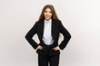 © makedonski2015 - A female executive donning a smart business ensemble stands out against a simple white background, encapsulating the business sphere