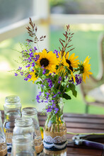 DIY Wedding Flower Arrangement On Table With Wild Sunflowers And Purple Forget-me-not Tree Flowers