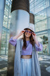 © Big Shot Theory - Vertical view of beautiful young woman in sunglasses and oversize clothes.