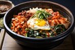 korean bibimbap in a hot stone bowl with kimchi