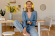 © mary_markevich - young pretty stylish smiling woman relaxing at home listening to music on earphones