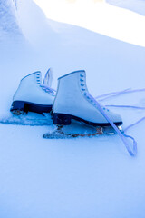 Wall Mural - Figure skates over snowy background with copy space