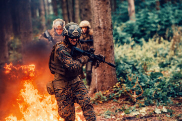 Soldier in Action at Night in the Forest Area. Night Time Military Mission jumping over fire