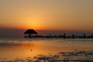 Wall Mural - Punta Coco sunset wooden deck pier leading into ocean. In Holbox Quintana Roo Mexico.