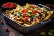 nachos arranged in layers with toppings in a casserole dish
