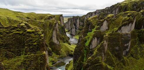 Canvas Print - Scenic landscape featuring a tranquil stream winding through a picturesque mountain range, Iceland