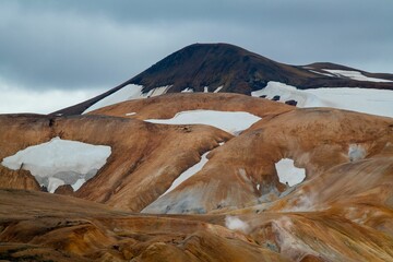 Wall Mural - Aerial view of a snow-covered mountain surrounded by brown hills in the background, Iceland