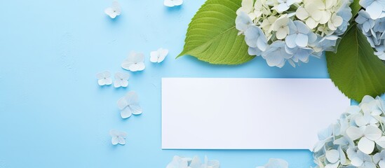 Aufkleber - A top-down view of a beautiful composition featuring hortensia flowers and a blank card on a light blue