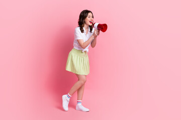 Full length photo of excited funky woman dressed white shirt screaming bullhorn empty space isolated pink color background