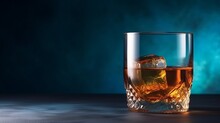 A Glass Of Whisky, Cognac With An Ice Cube On An Old Vintage Blue Background, With Copy Space, Place For Text, Banner And Product Advertisement Mock Up