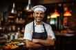 © Ms VectorPlus - Smiling male chef stands against the background of the kitchen in a cafe
