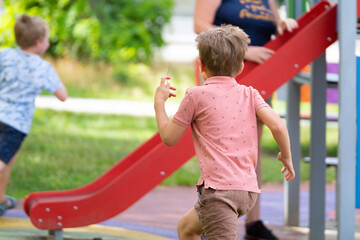 Portrait of six year old boy on playground in summer..