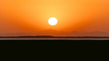 Epic Sunset Landscape Sky With Big Bright Sun Going Behind The Mountains In Egypt.