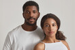 © Seventyfour - Minimal portrait of young black couple looking at camera against white background