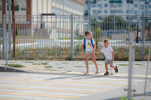 Brother And Sister Run Across A Pedestrian Crossing. Children Run Along The Road To Kindergarten And School.Zebra Traffic Walk Way In The City. Concept Pedestrians Passing A Crosswalk