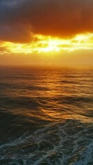 Wall Mural - aerial view on big waves of atlantic ocean and dramatic sunset sky. vertical video