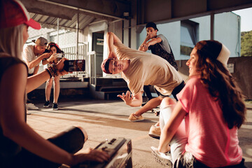 Wall Mural - Group of young people break dancing in a parking lot and recording with their smart phone