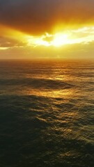 Wall Mural - aerial view on big waves of atlantic ocean and dramatic sunset sky. vertical video