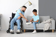 © Pixel-Shot - Little boy and his father in wheelchair reading book at home