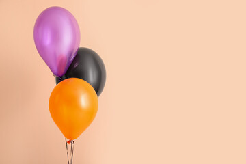 Different Halloween balloons on beige background