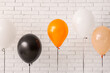© Pixel-Shot - Different Halloween balloons near light brick wall in room