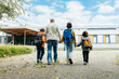 © Elena Medoks - Back to school. A father walks his children to school. Beginning of the school year. Parental care for children.