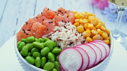 Poster - Poke bowl with salmon, rice, edamame beans, yellow corn, radish, circling on table. Healthy food, Asian raw meal. traditional Hawaiian raw fish salad. Japanese food.