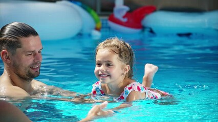 Poster - Mother with father and daughter resting and swimming in a pool in summer, learning to swim