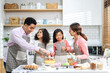 © Art_Photo - Portrait of enjoy happy love asian family father and mother with little asian girl daughter child play and having fun cooking food together with baking cookie and cake ingredient in kitchen