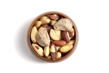 Wall Mural - Brazil nuts in wooden bowl isolated on white. Peeled brazil nuts, top view