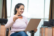 © PRASANNAPIX - Indian woman using laptop and bank card at office