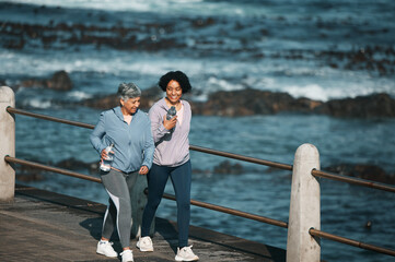 Canvas Print - Fitness, walking and woman and senior mother by ocean for healthy body, wellness and cardio on promenade. Sports, happy and female people on boardwalk for exercise, marathon training and workout