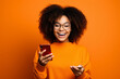 © AI_images - girl with phone on orange background.