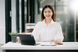 © Nuttapong punna - Successful Asian Businesswoman Analyzing Finance on Tablet and Laptop at modern Office Desk tax, report, accounting, statistics, and analytical research concept.