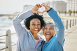 © aLListar/peopleimages.com - Heart, hands and fitness with portrait of friends at beach for health, support and love. Motivation, happy and wellness with mature women and sign in nature for exercise, workout and emoji icon